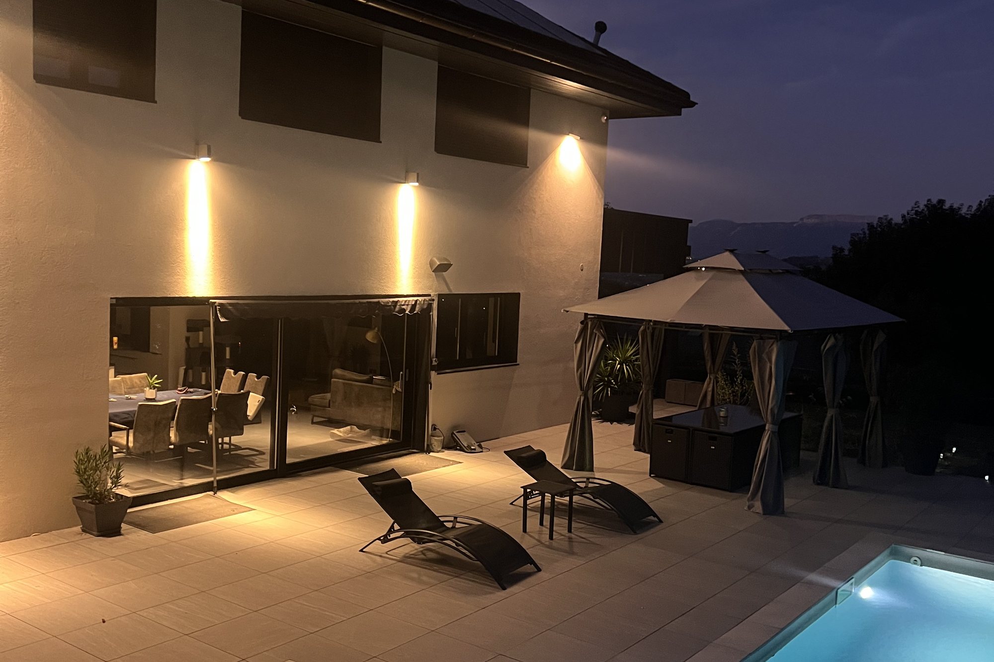 Piscine chauffée illuminée la nuit, face à la villa