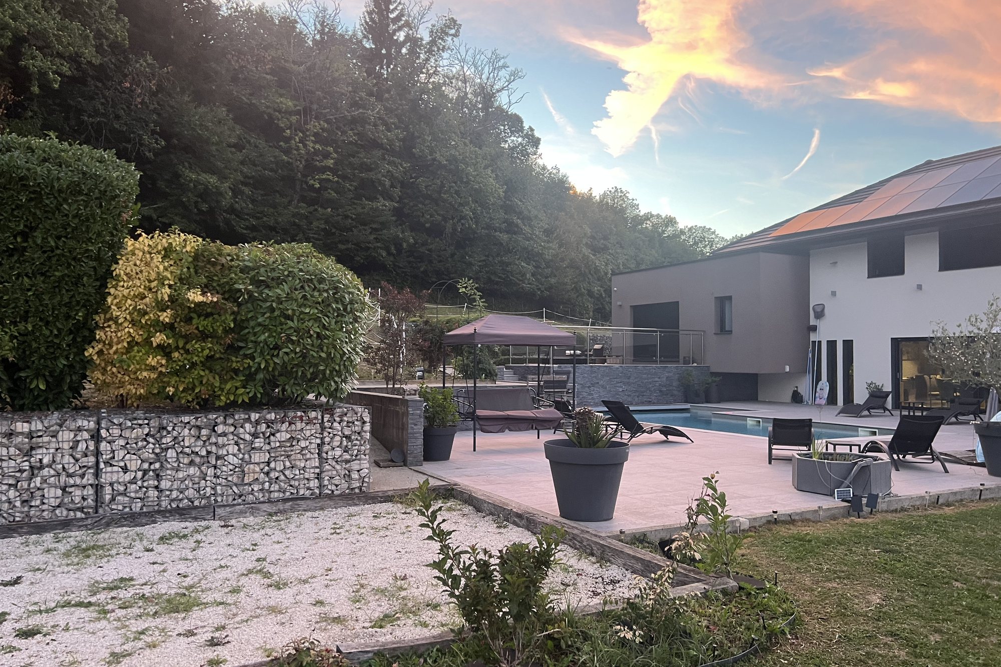 Grande terrasse et piscine de la villa contemporaine en soirée