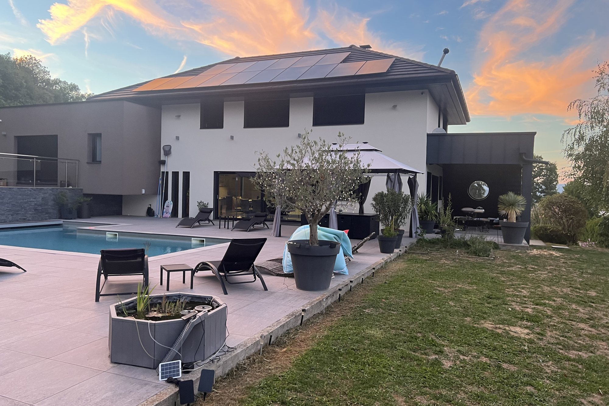 La villa, sa terrasse et sa piscine chauffée au coucher du soleil, à Rumilly en Haute-Savoie